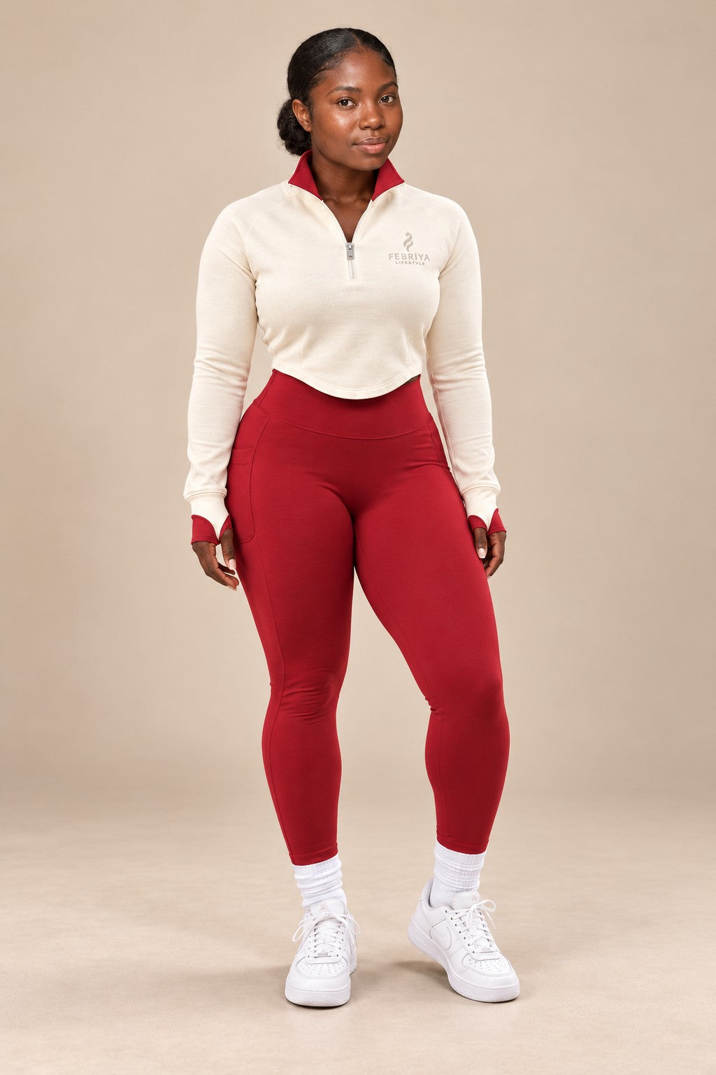 Woman in an ivory quarter-zip top and ember leggings